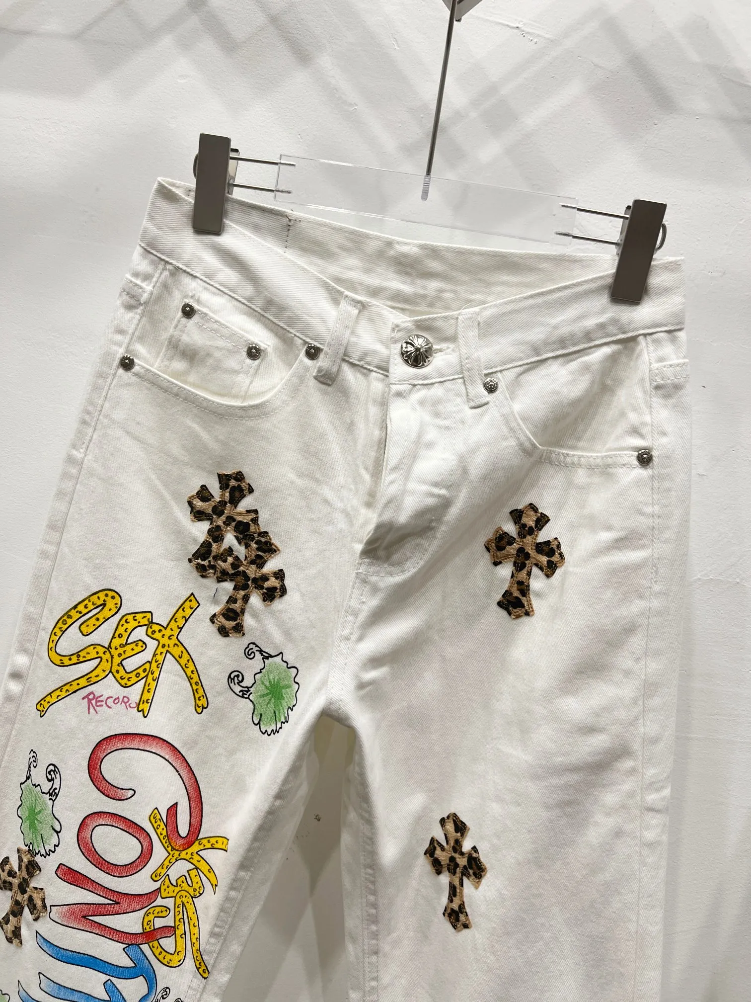 P260 Style No.: (c031) Chrome Hearts & Chrome Hearts high street jeans with leopard print and vintage graffiti paintings on a white background. Chrome Hearts are the most popular pants in color. Made of beaded canvas fabric, heavy washing makes the upper body of the fabric more textured and the pants are tall and straight! The three-dimensional cutting of the whole trousers is a masterpiece! The hardware is customized by zp. The beaded canvas fabric is thick and soft after being washed. It has good breathability. Customized small leather label. Unique design. The details are simple and elegant, and the workmanship is exquisite. The whole trousers are neatly routed and the details are in place!  Trendy people have been disappointed. From the quality selection of fabrics, the tailoring of details, and the matching of patterns, everything is impeccable! The upper body is so handsome when worn...it can be easily worn by men, women and children! The craftsmanship is made of heavy-duty washed pure cotton denim fabric. After washing, it is soft and thick and looks very stylish when worn. Color: White Size: 28 30 32 34 (S-XL)